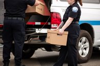 Tabac - 17 - <p>Inspecteurs chargeant des caisses de cigarettes de contrebande dans une camionnette de Revenu Québec</p>