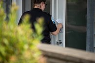 Hébergement - 04 - <p>Inspectrice laissant un dépliant à la porte d'un établissement d'hébergement touristique</p>
